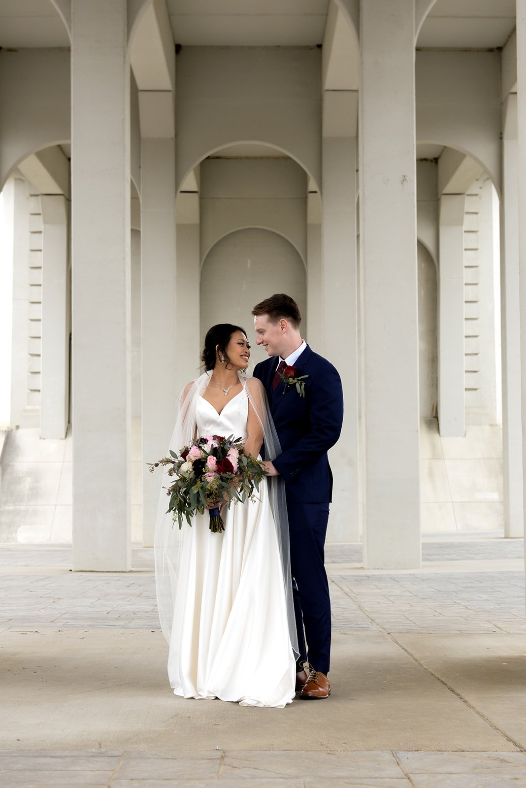 Bride and groom kissing under white columns in Chattanooga, Tennessee