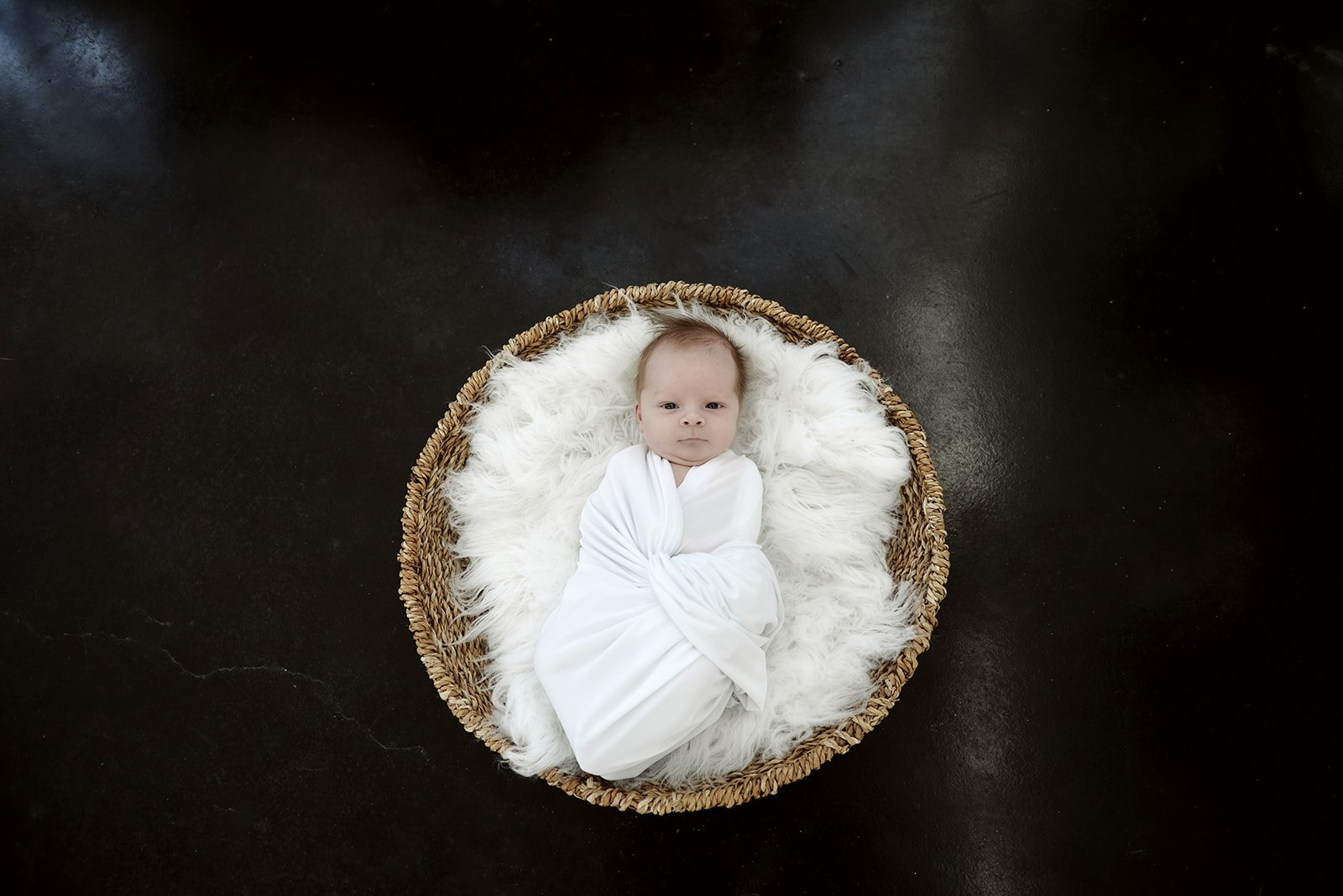 Newborn in basket overhead shot