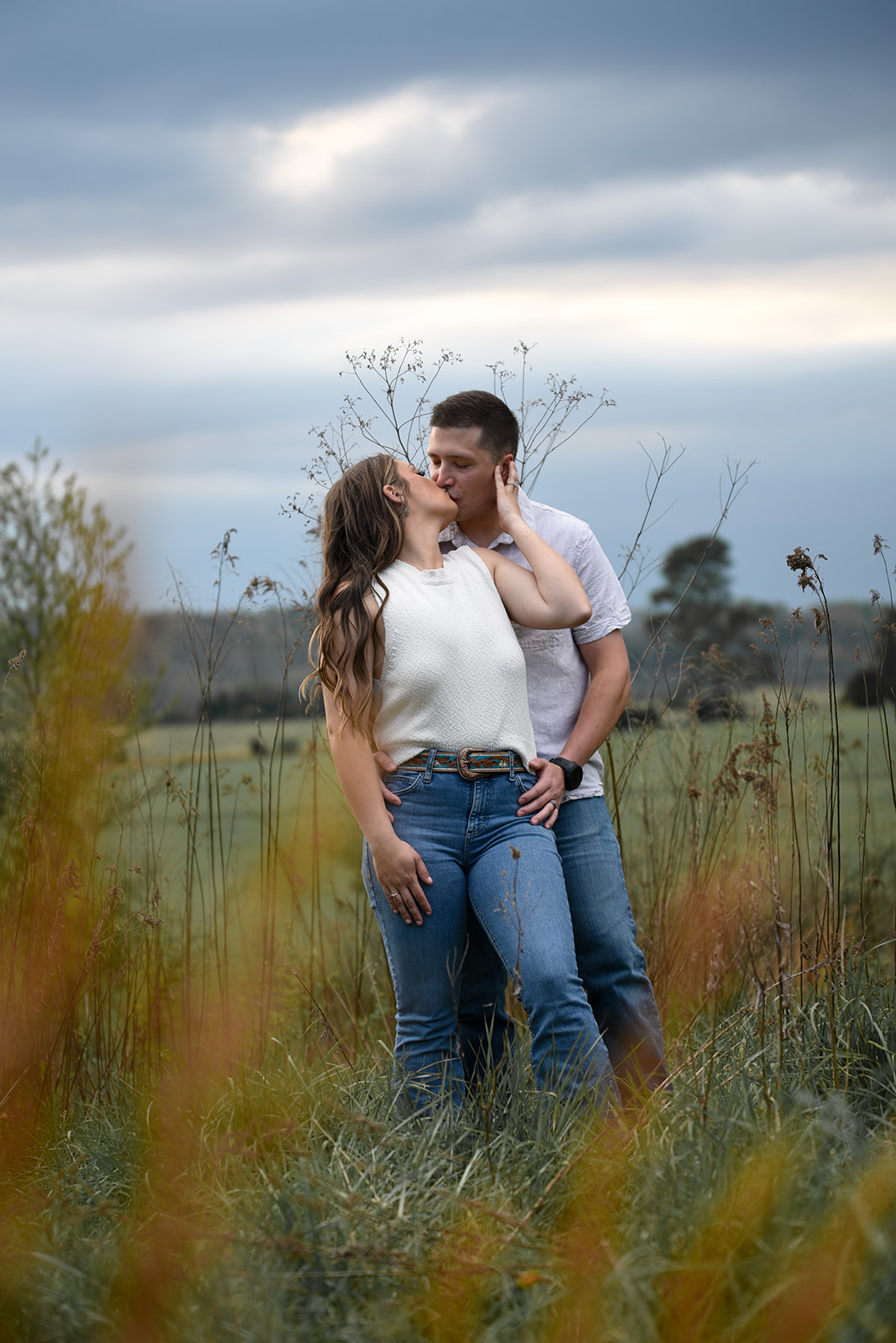 Engaged couple walking through open field with old-growth oaks at Fort Oglethorpe Georgia