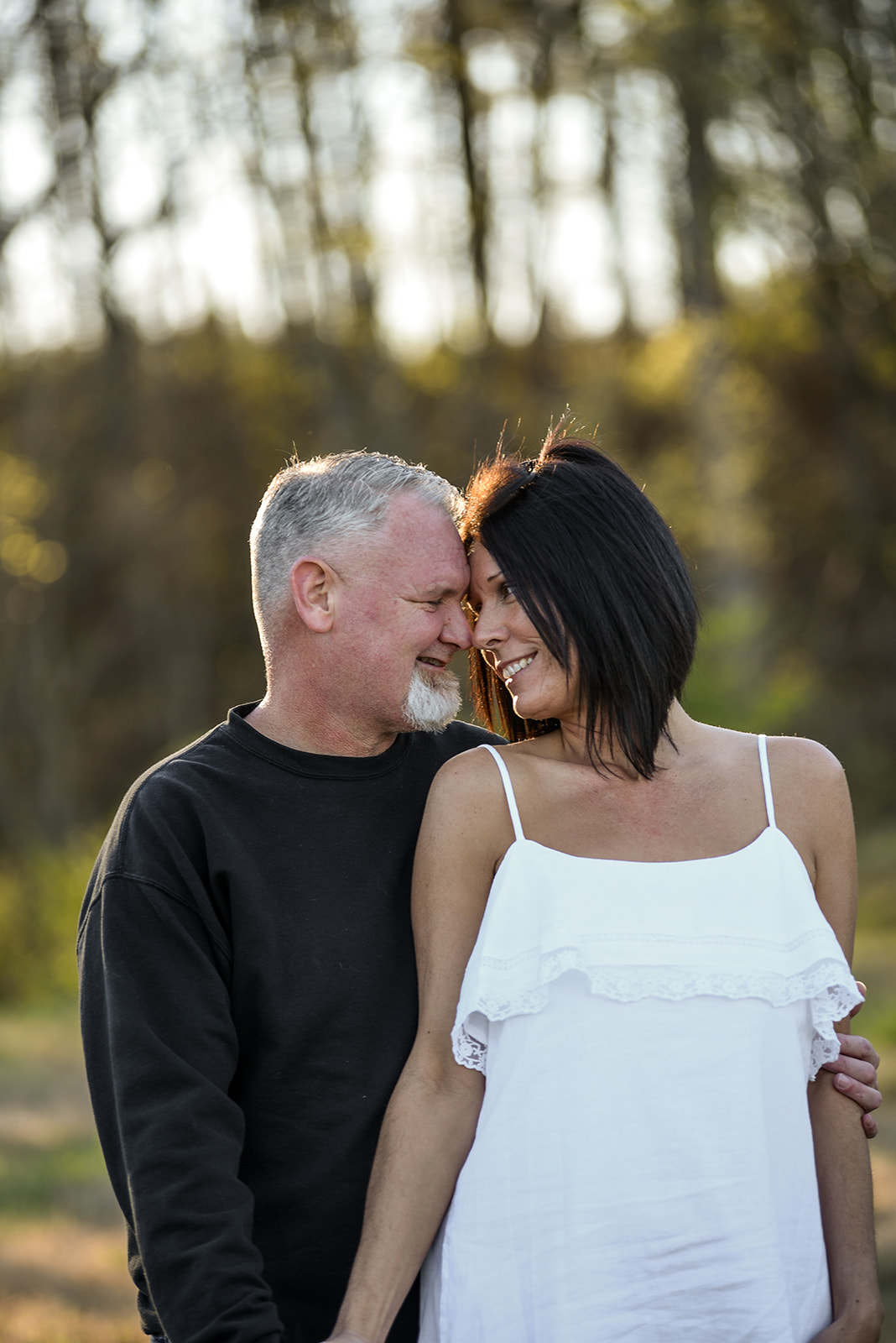 Couple in coordinated neutral outfits during engagement session at Duluth Georgia park