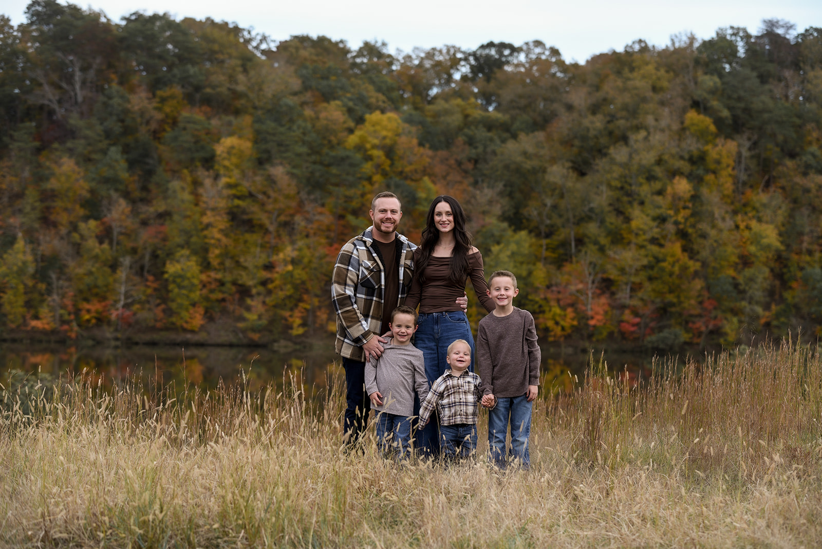 Father lifting toddler in the air during family session at Kennesaw Mountain, both laughing