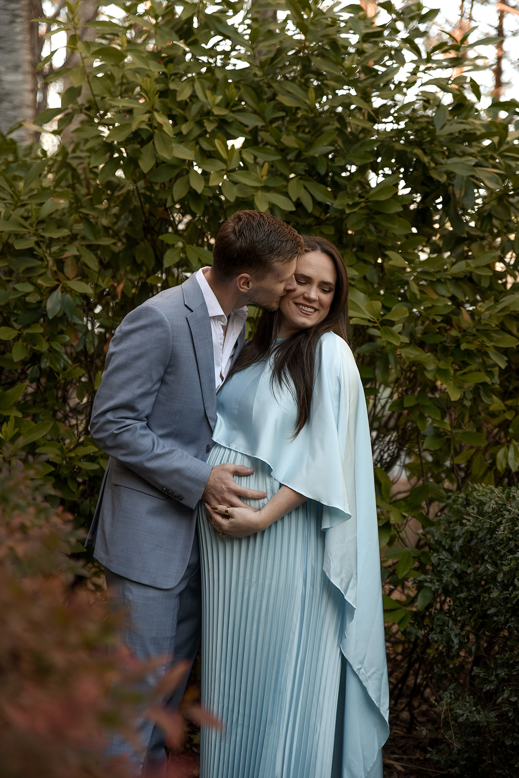 Couple at maternity session in Cave Spring Georgia, brick street backdrop and Victorian storefront