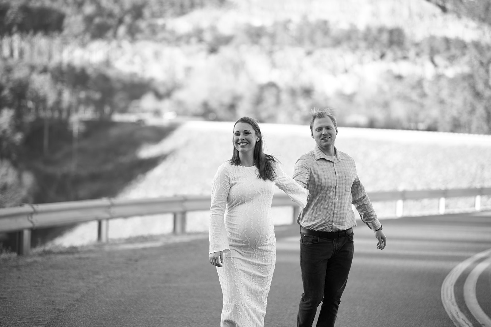 Maternity portrait of couple in a field near Ball Ground Georgia, Cherokee County hills in background, golden hour