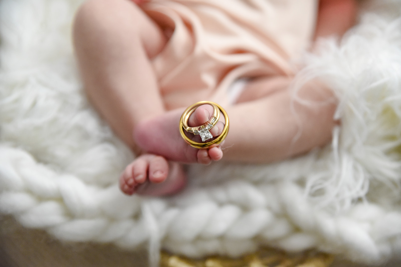 Family portrait with newborn baby, parents gazing at each other over the baby's head, warm light in background