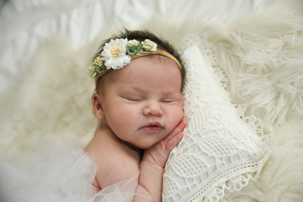 Newborn baby photographed in soft natural light during lifestyle session in Georgia