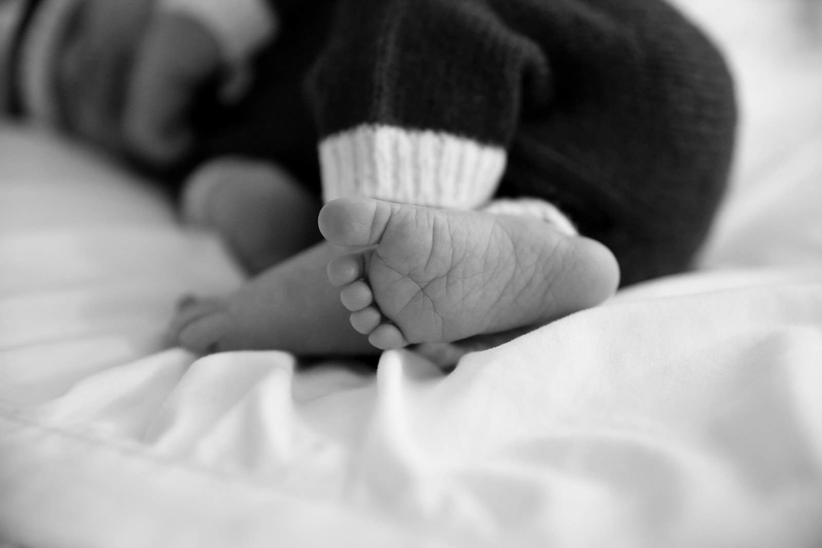 Newborn baby in white wrap during lifestyle session, soft window light from Acworth home setting