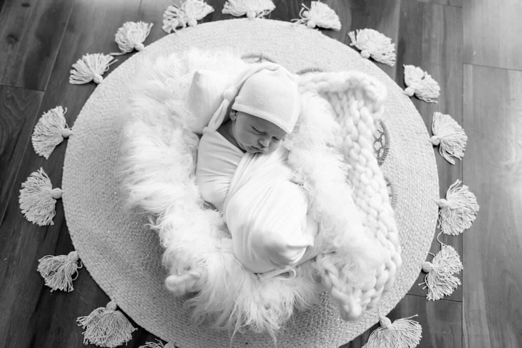 Black and white newborn photograph of sleeping baby in soft natural light