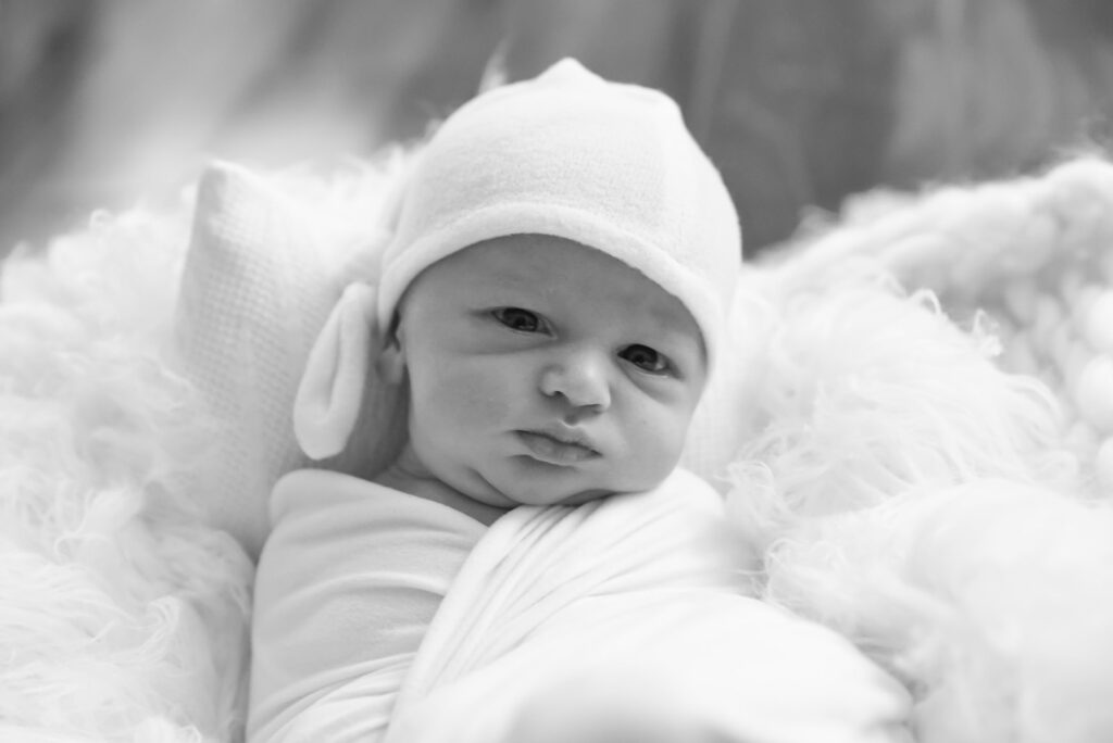 Black and white newborn photograph of sleeping baby in soft natural light